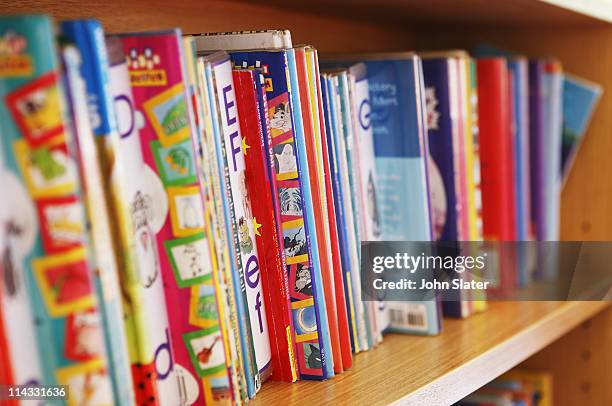 childrens reading books on bookshelf - kids books stock pictures, royalty-free photos & images