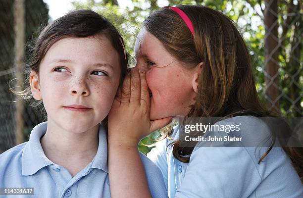 school girls whispering to each other