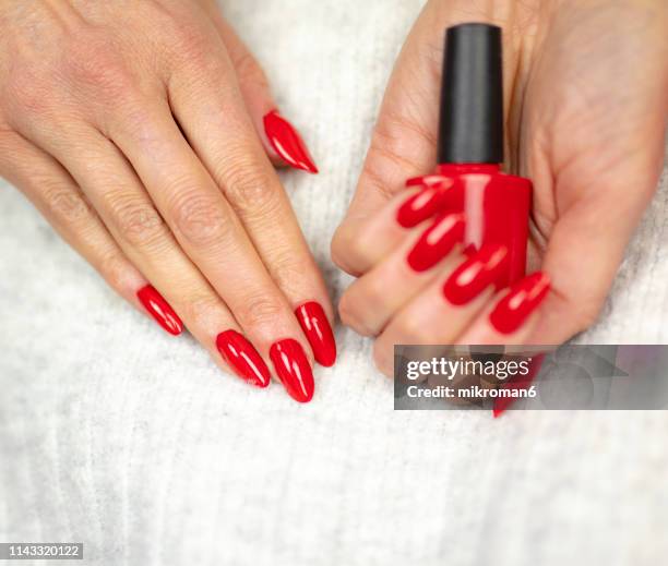 close-up of woman fingers with nail art manicure in red color - red nail polish stock pictures, royalty-free photos & images