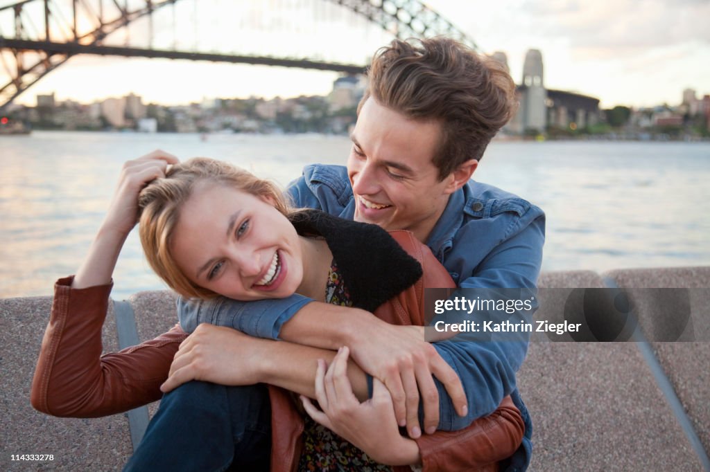 Couple embracing in front of Sydney Harbour Bridge