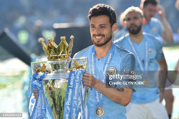 Manchester City's Spanish midfielder David Silva poses with the Premier League trophy after their 4-1 victory in the English Premier League football...