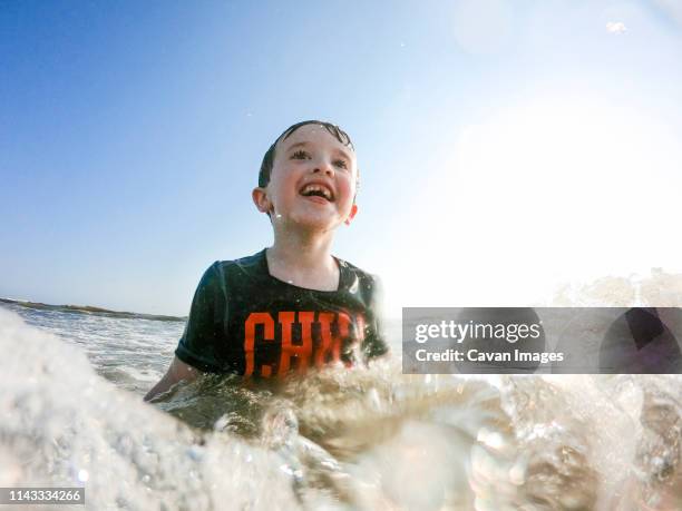 happy boy swimming in sea against sky during sunny day - newport rhode island 個照片及圖片檔