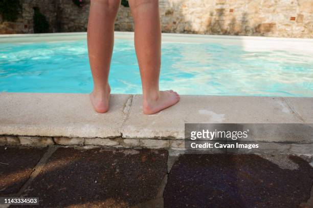 low section of boy standing on poolside - boy barefoot rear view stockfoto's en -beelden