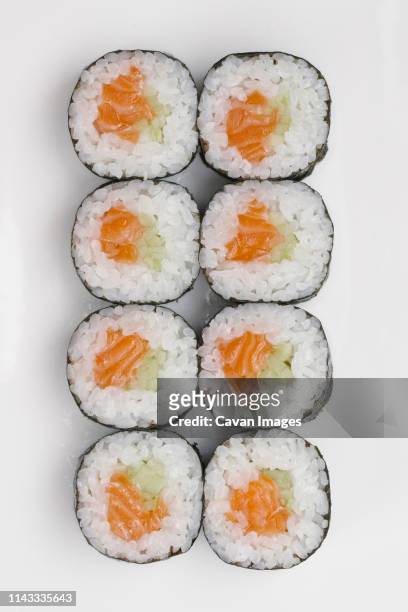 close-up of sushi rolls arranged on white background - maki sushi stockfoto's en -beelden