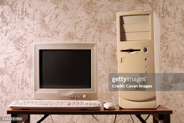 computer with keyboard and mouse by cpu on wooden table against wall - retro computer monitor stock pictures, royalty-free photos & images