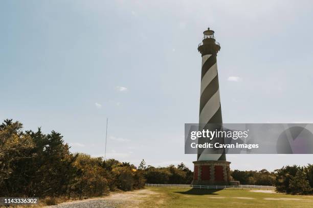 lighthouse against sky during sunny day - north carolina lighthouse stockfoto's en -beelden