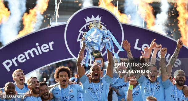 Manchester City's Belgian defender Vincent Kompany holds up the Premier League trophy after their 4-1 victory in the English Premier League football...