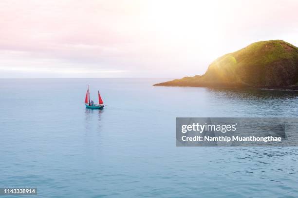 the sailboat floats on the sea with the mountains. - nosy be stock-fotos und bilder