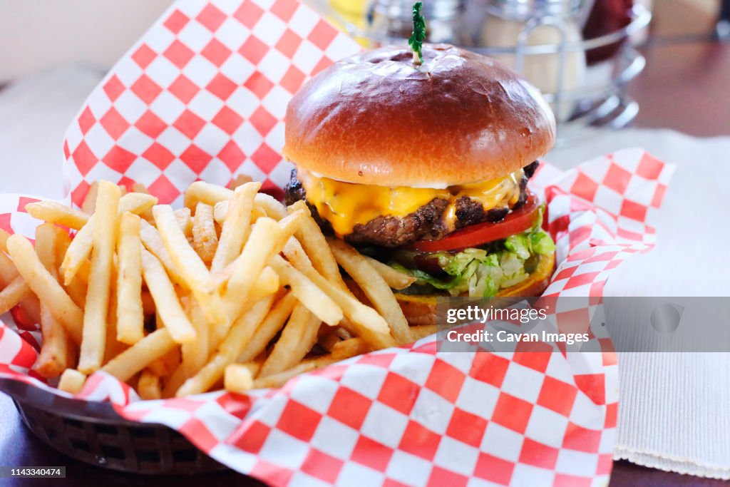 High angle view of burger with French fries served on table in restaurant