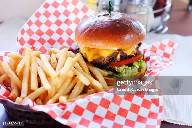 high angle view of burger with french fries served on table in restaurant - burger and fries stock pictures, royalty-free photos & images