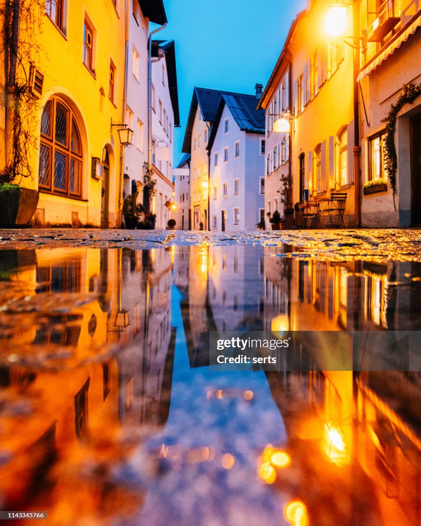 Old Füssen houses reflections at rainy night on the water