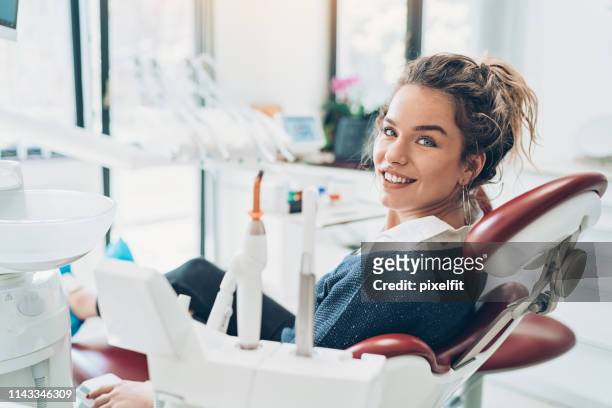 young woman sitting on a dentist's chair - toothy smile stock pictures, royalty-free photos & images