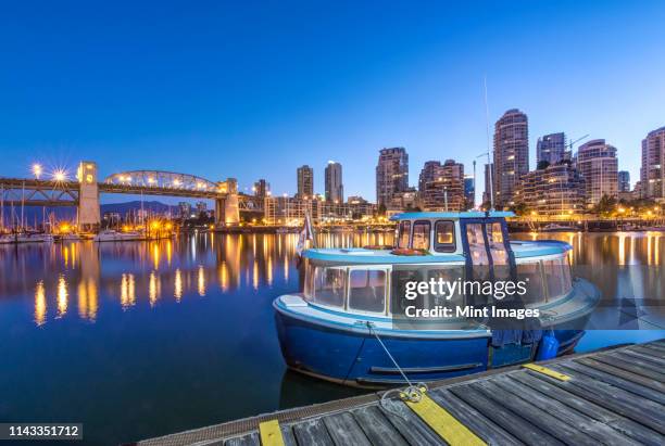 waterfront skyline and harbor illuminated at night, vancouver, british columbia, canada - granville stock pictures, royalty-free photos & images