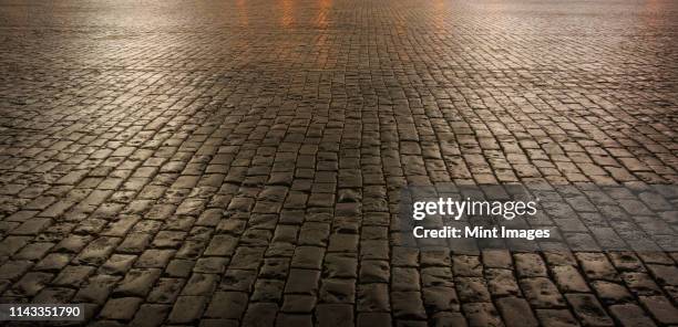 close up of cobblestone street at night - cobblestone stock pictures, royalty-free photos & images