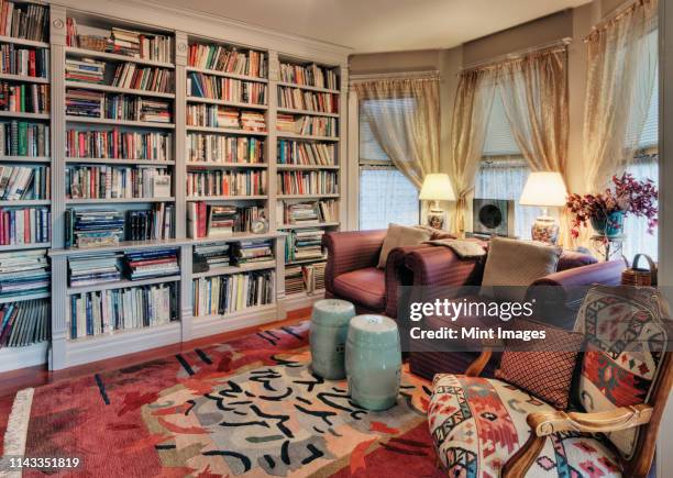 armchairs and bookcases in living room - library empty stock pictures, royalty-free photos & images