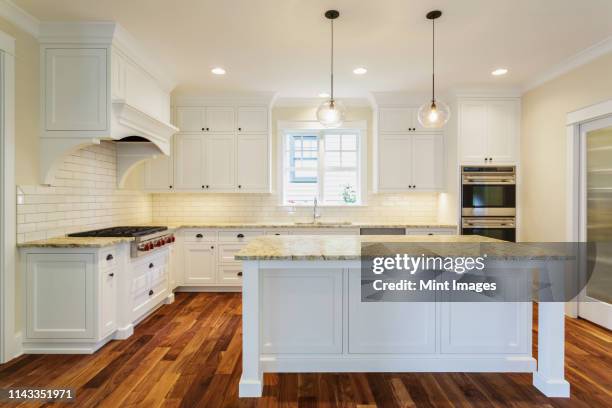 island and counters in luxury kitchen - pendant light - fotografias e filmes do acervo