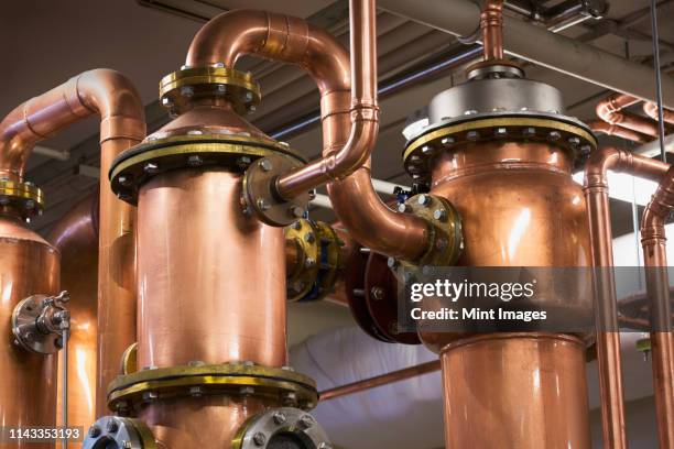 close up of copper stills in distillery - destillation stock-fotos und bilder