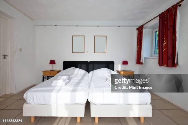 twin beds pushed together in bedroom - eenpersoonsbed stockfoto's en -beelden
