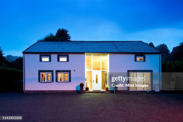 modern house illuminated at twilight - house dusk stock pictures, royalty-free photos & images