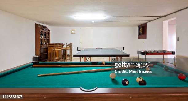 pool table and ping pong table in basement - pool cue sport stock pictures, royalty-free photos & images