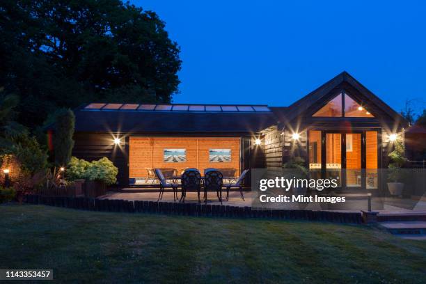 illuminated modern house - patio lights stock pictures, royalty-free photos & images