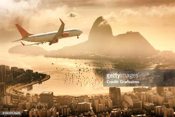 airplane flying over rio de janeiro guanabara bay with sugarloaf mountain - rio de janeiro aerial stock pictures, royalty-free photos & images