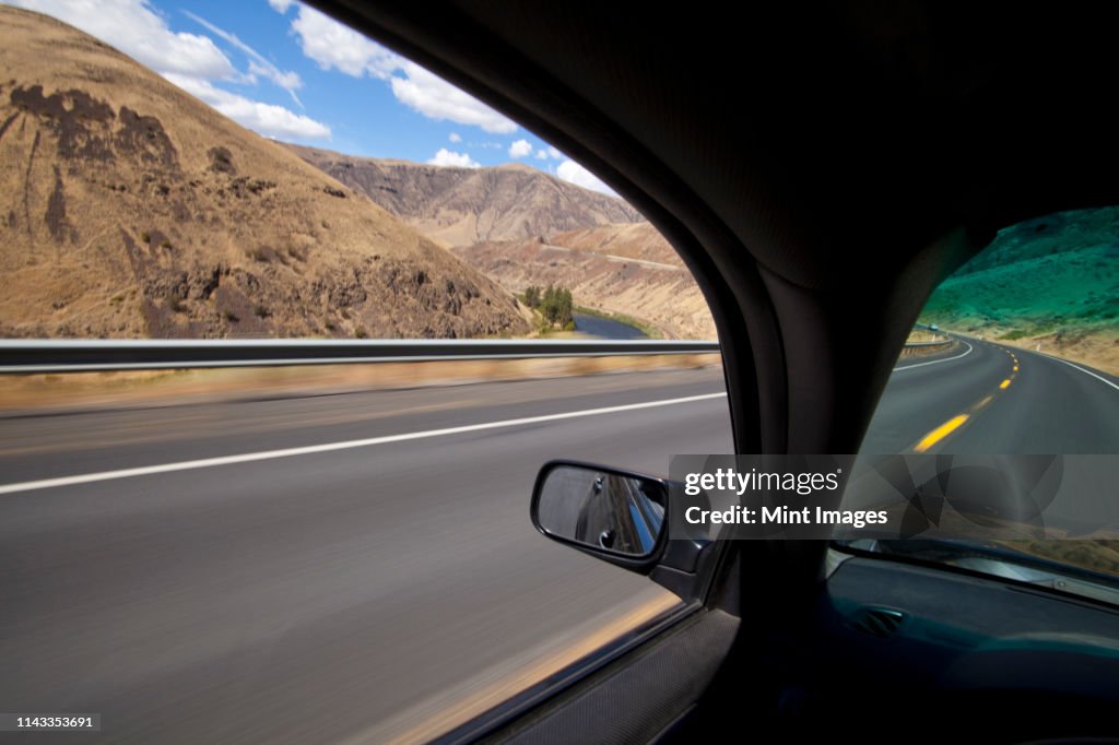 Car driving on road through Yakima River Canyon, Washington, United States