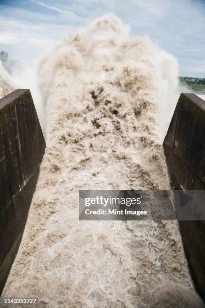 water crashing through spout - barrage photos et images de collection