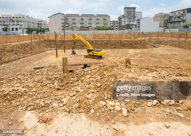 digger working on construction site - racine terre photos et images de collection