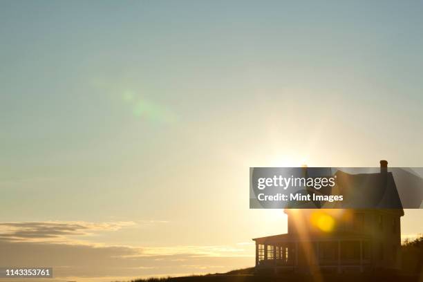 sun shining behind rural house - twilight house stock pictures, royalty-free photos & images