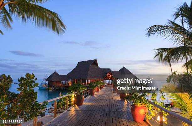 deck and restaurant over tropical ocean, bora bora, french polynesia - bora bora foto e immagini stock