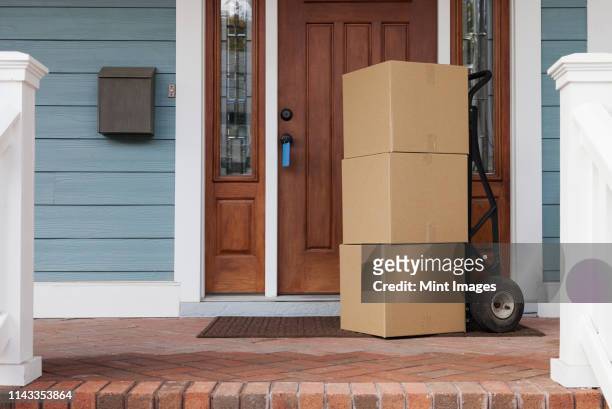 cardboard boxes on front porch of new house - bezittingen stockfoto's en -beelden