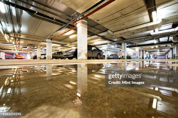 ceiling reflected in wet parking structure floor - unterwasser überschwemmungen innen stock-fotos und bilder