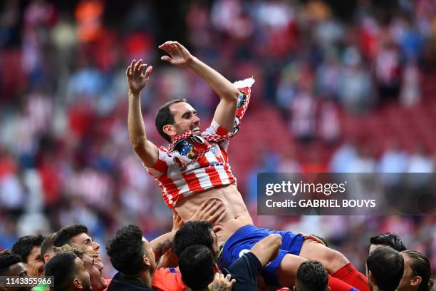 Atletico Madrid's Uruguayan defender Diego Godin celebrates with teammates after the Spanish League football match between Atletico Madrid and...