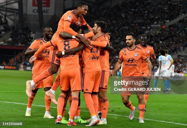 Lyon's Ivorian forward Maxwel Cornet is congratulated by Lyon's players after scoring a goal during the French L1 football match between Olympique de...