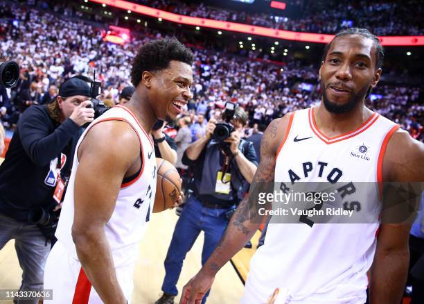 Kawhi Leonard of the Toronto Raptors speaks with Kyle Lowry after sinking a buzzer beater to win Game Seven of the second round of the 2019 NBA...