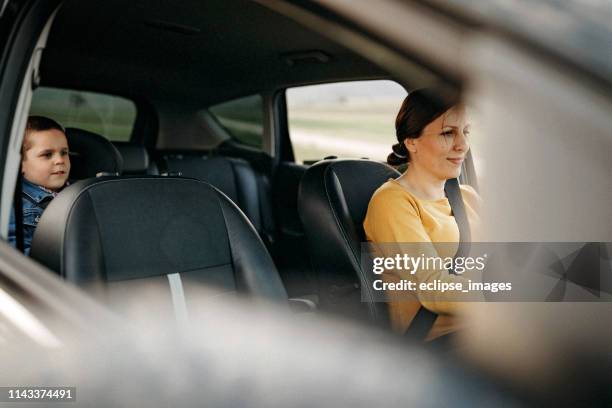 mother driving her son to home - mini van driving stock pictures, royalty-free photos & images