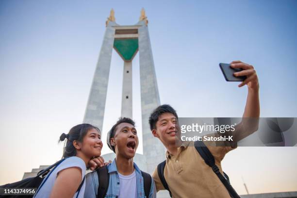 multi-ethnic asian friends taking selfie picture in public park - daily life in manila imagens e fotografias de stock