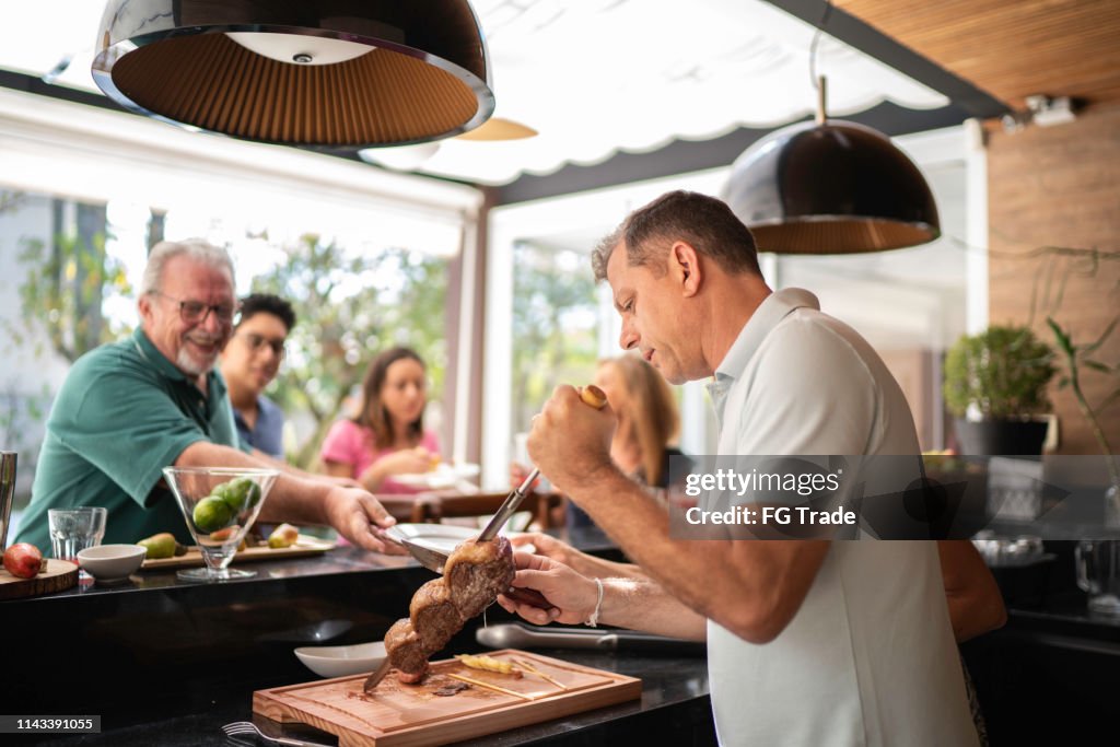 Carne do picanha do corte do homem durante o assado