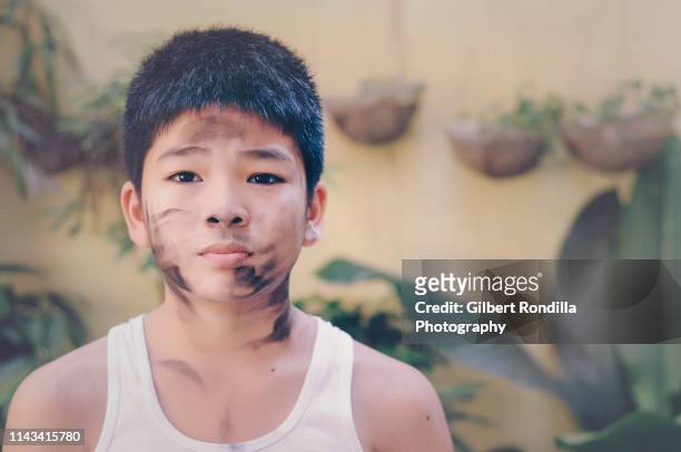 boy with charcoal smear on face - ruß stock-fotos und bilder