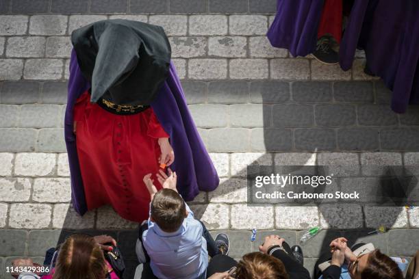 un nazareno entregando un caramelo. - entregando stock pictures, royalty-free photos & images