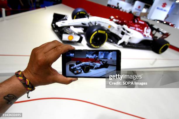 Visitor takes a photo with his smartphone of a Formula One Suzuki racing vehicle at the Automobile Trade Fair 2019 in Barcelona.