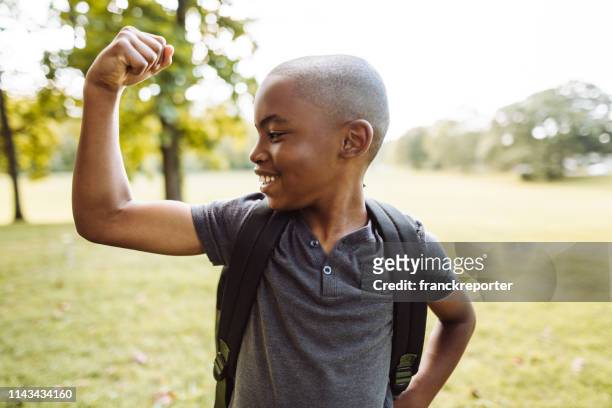 petit gosse montrant le muscle - musculation des biceps photos et images de collection