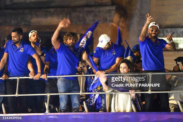 Mumbai Indians cricket player Lasith Malinga , team captain Rohit Sharma , player Hardik Pandya and team members gesture and celebrate as they travel...