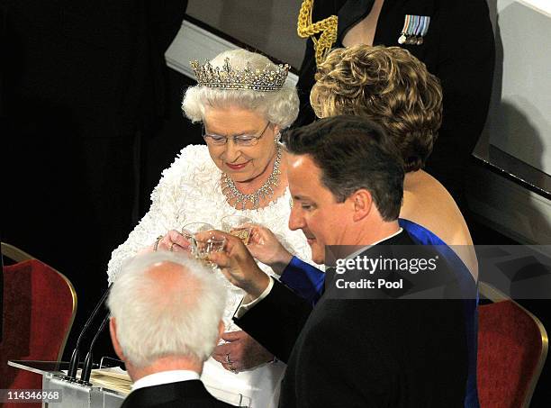 Britain's Queen Elizabeth II toasts with Irish President Mary McAleese and British Prime Minister David Cameron after giving a speech at Dublin...