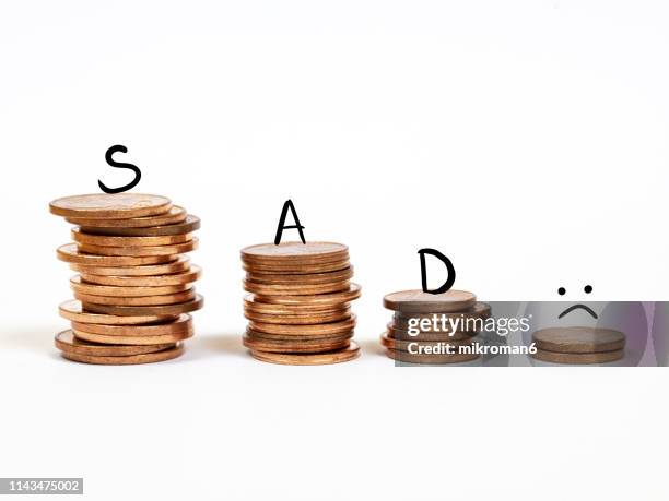 money in stacks with sad face on top - poverty reduction stock-fotos und bilder