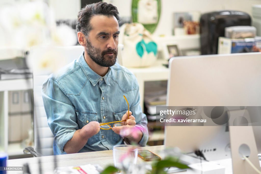 Serious disabled businessman using computer