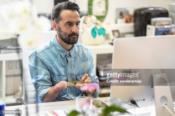 serious disabled businessman using computer - physical disability stock pictures, royalty-free photos & images