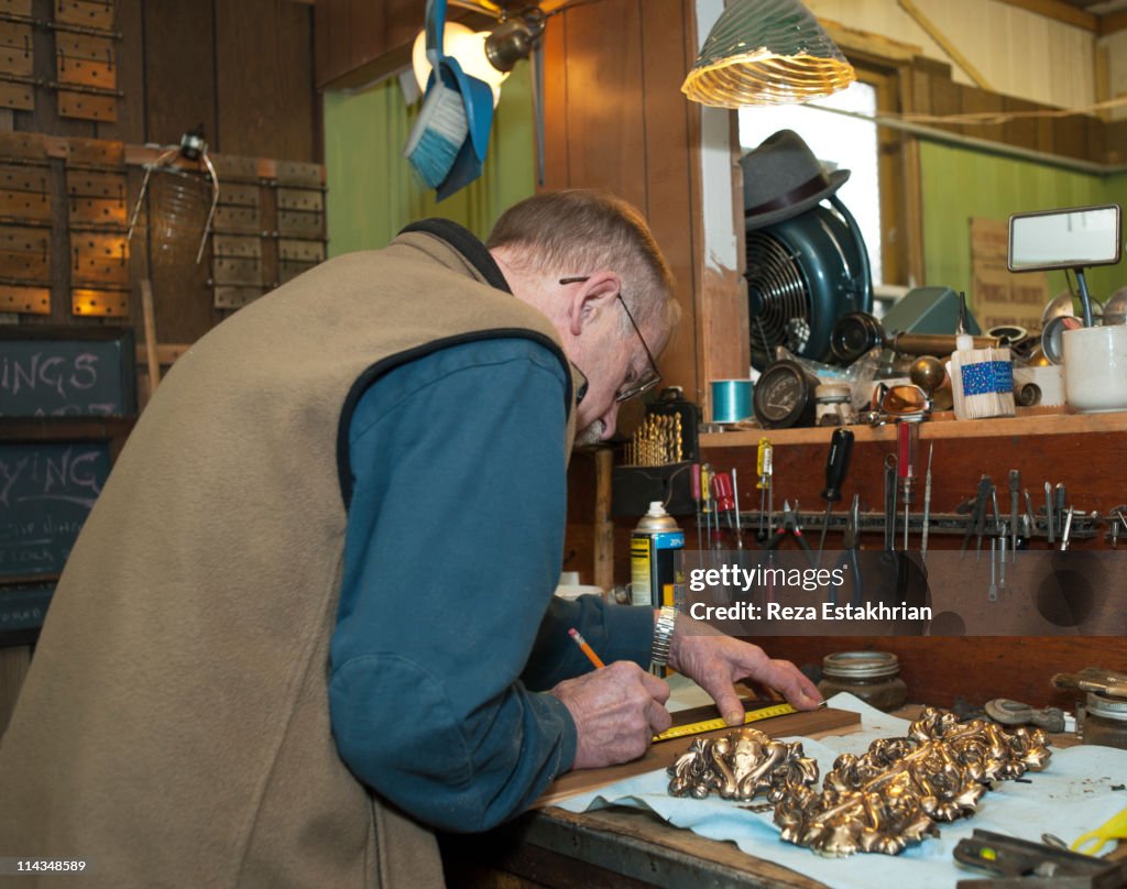 Senior man measures wood panel