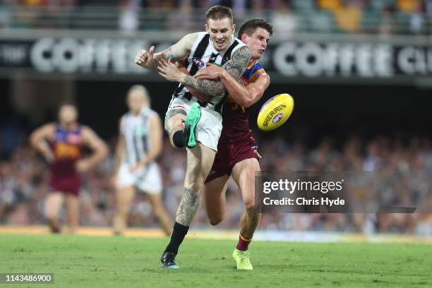 Dayne Beams of the Magpies kicks while tackled by Jarrod Berry of the Lions during the round 5 AFL match between Brisbane and Collingwood at The...